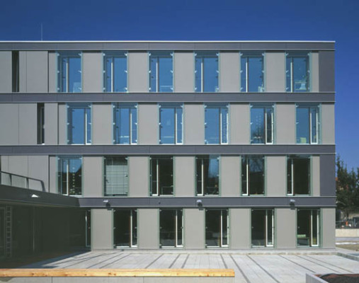 Großformatige Glaselemente als Kastenfenster und Faserzementplatten gliedern die Fassade