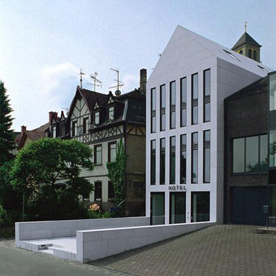 Die Fassadengestaltung suggeriert drei Geschosse, tatsächlich verbergen sich hinter den Fenstern jedoch vier Stockwerke