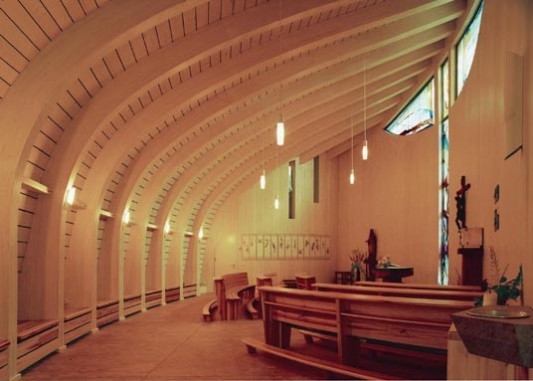 Die Brettschichtholzträger wölben sich wie die Gräten eines Fisches über den Kirchenraum
