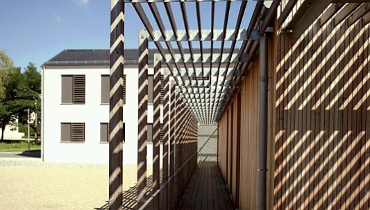 Die offene Holzpergola erweitert den Jugendklub zum Hof