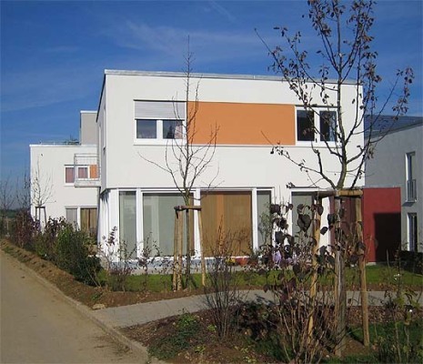 Südseite eines Wohnhauses mit kleinem Garten und Terrasse 