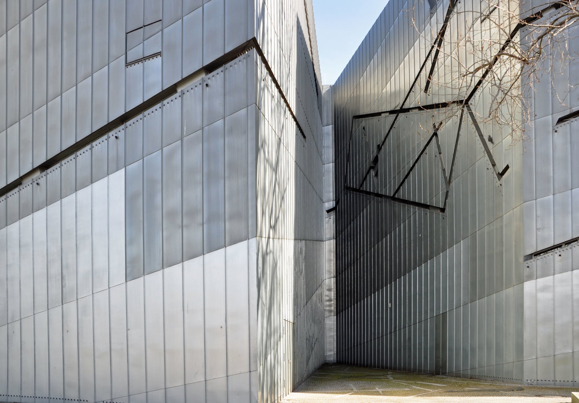 Die vorgehängte, hinterlüftete Fassade ist mit Titanzinkblech verkleidet.