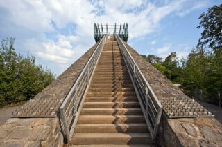 Die unteren zwei Drittel der Treppe bestehen aus Naturstein, das letzte Drittel aus Stahl und Glas.