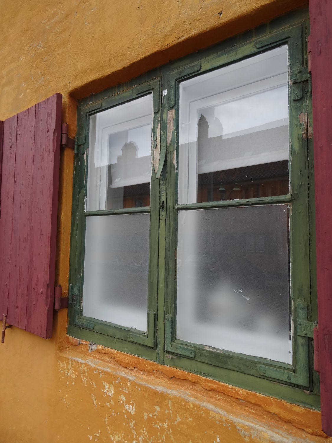 Fenster mit Winkelbändern und Läden mit Kloben
