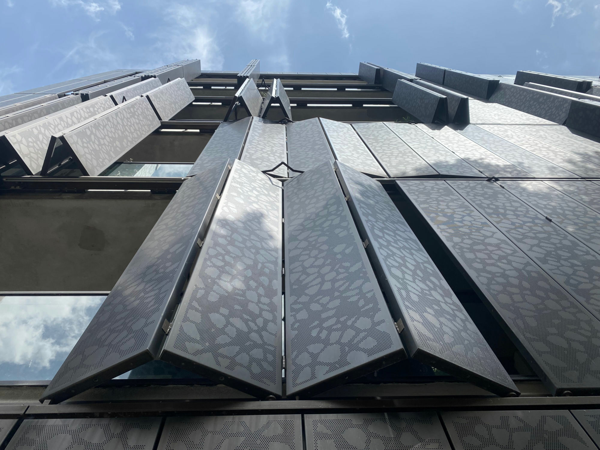 Manuell bedienbare, geschosshohe Faltschiebläden mit Rollen über Schienen vor den Loggien des Berliner Wohnquartiers „Marthashof“  von Grüntuch Ernst Architekten