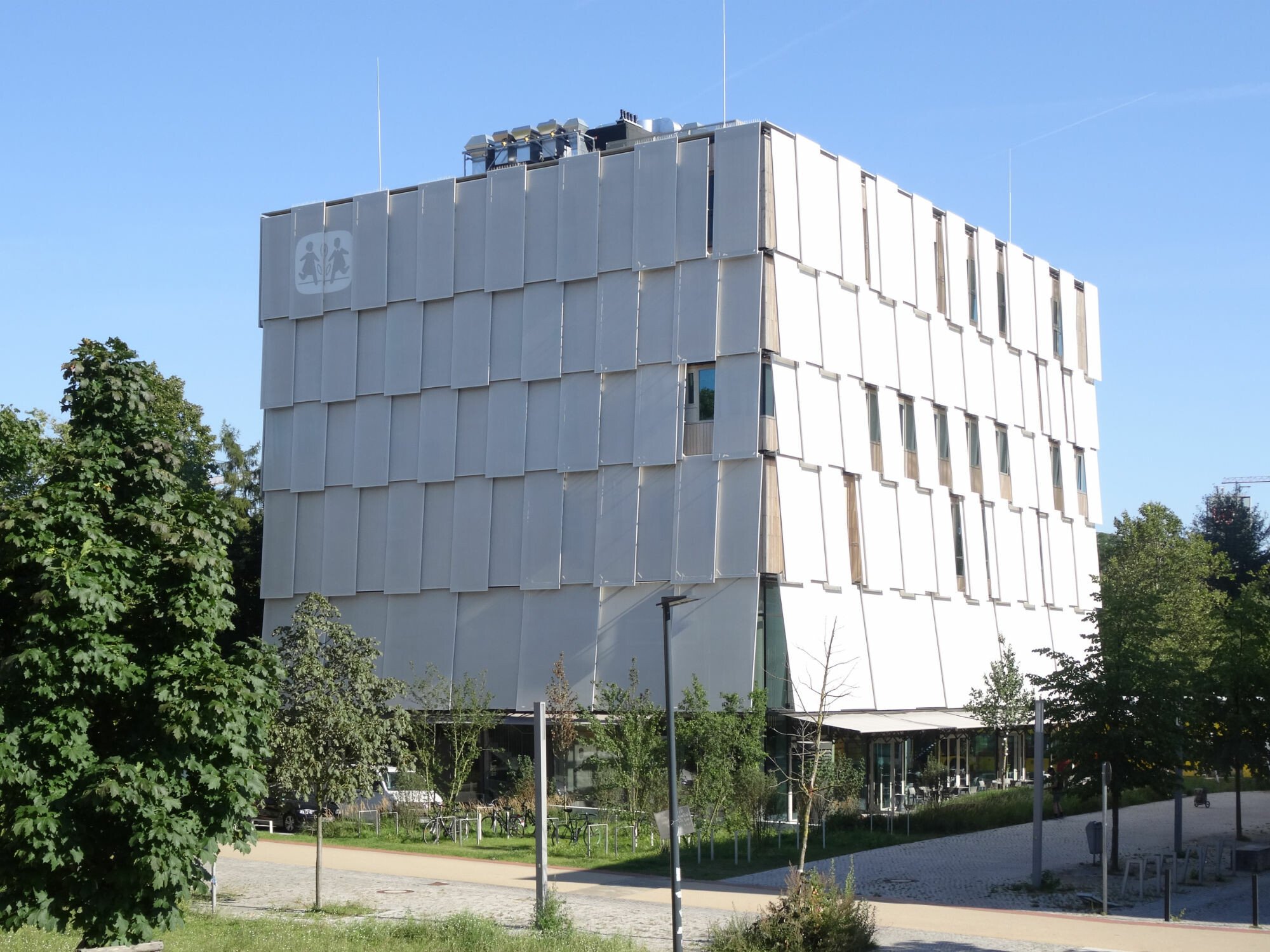 Die Fassade der Botschaft für Kinder in Berlin umschließen weiße Sonnenschutzscreens; Architektur: Ludloff Ludloff