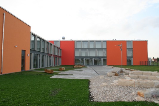 Hofseite mit verputzten Flächen in Rot und Orange