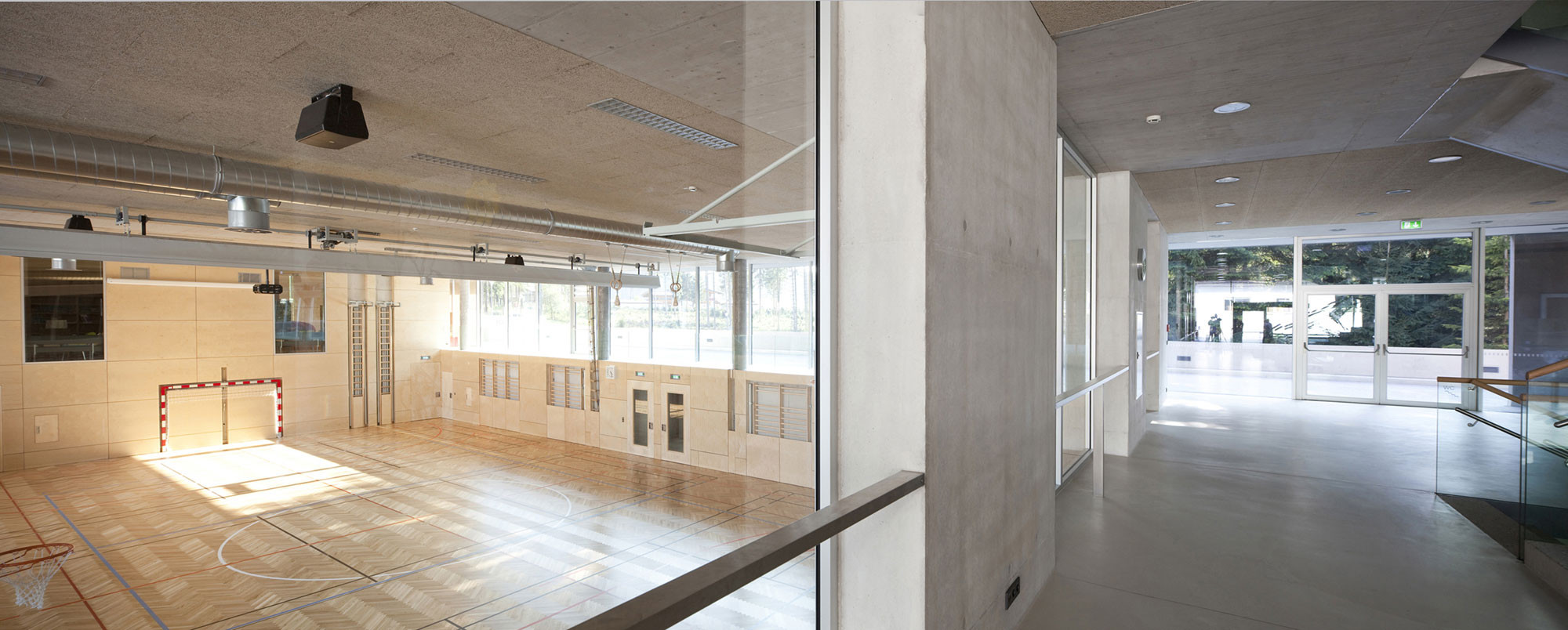Große Glasflächen erlauben Einblicke von der Aula in die Sporthalle