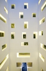 Lichtschacht mit geometrischen Öffnungen zu den umlaufenden Korridoren, unten der Eingangssteg