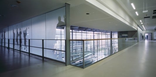 Einige Glasscheiben wurden mit scherenschnittartigen, gläsernen Silhouetten von Personengruppen bedruckt