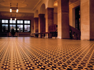 Die Erfindung des elastischen Bodenbelags geht auf einen Zufall zurück, im Bild ein Inlaid-Linoleum mit einem Muster von Peter Behrens im Rathaus Bremen.