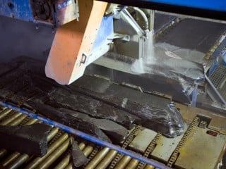 Der erste Schritt der Übertage-Produktion beginnt mit dem Zuschnitt der Schieferblöcke in die zur weiteren Verarbeitung benötigte Form