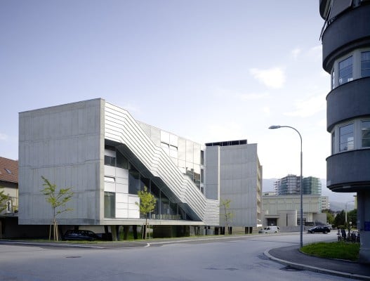 Die außenliegende Treppe, umhüllt von Aluminium, prägt den kleineren Baukörper