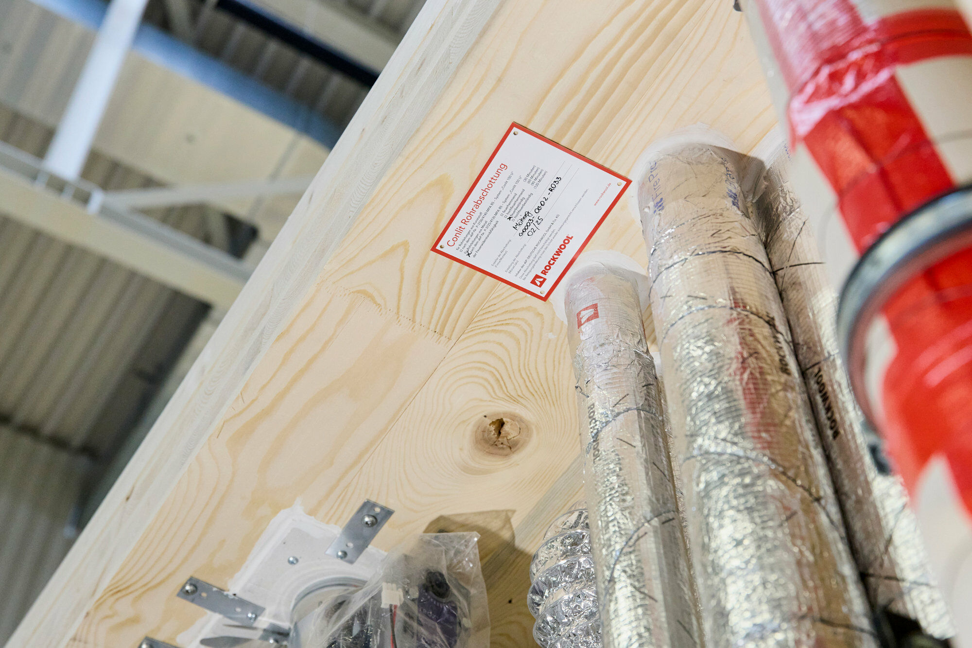 Brandabschottung: Kaschierte Steinwolle ummantelt die haustechnischen Leitungen eines Holzmodulbaus.
