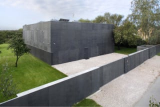 Monolithisch verschlossen und mit einer Mauer vom öffentlichen Bereich getrennt