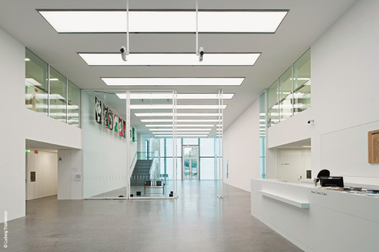 Der Terrazzoboden im zweigeschossigen Foyer wird von Geschoss zu Geschoss heller