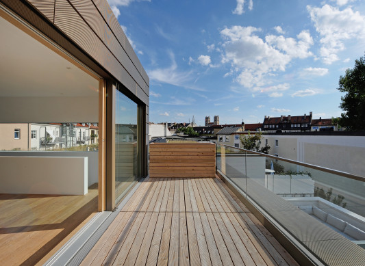 Eine Dachterrasse aus Lärchenholzplanken erweitert die exklusiven Eigentumswohnungen
