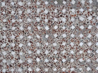 Terrazzo bezeichnet einen meist fugenlosen Bodenbelag aus mineralischem Bindemittel und Gesteinskörnungen, der durch Schleifen und Polieren eine homogene, glänzende Oberfläche erhält. Im Bild: Terrazzoboden in der anktiken Stadt Herculaneum am Golf von Neapel 