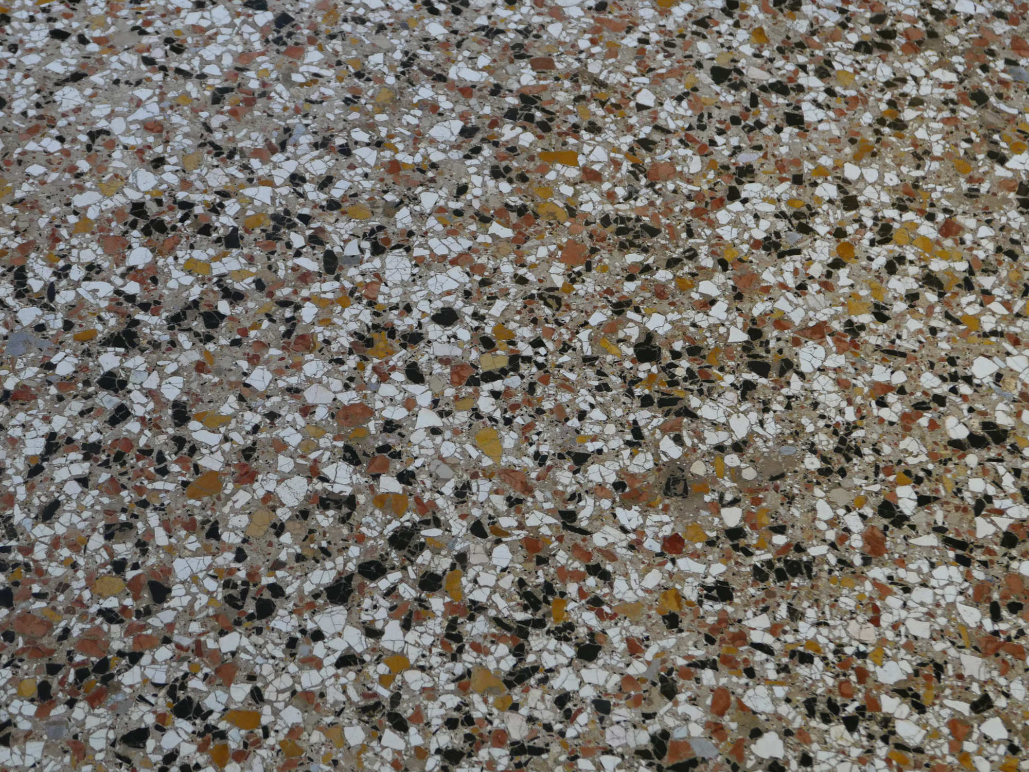 Traditionell besteht Terrazzo aus Zuschlägen wie Marmor, Kalkstein oder Dolomit, die mit Wasser und einem Bindemittel auf der Bodenfläche verteilt und später verdichtet und geschliffen werden.