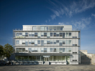 Beim Bürogebäude „The Box“ in Berlin, einem umgebauten Bestandsgebäude aus dem Jahr 1969, fügt sich der Edelstahlbehang S_enn mit seiner schlanken Bauweise dezent in die Vorhangfassade aus Aluminium-Streckmetall ein. Architektur: AHM Architekten, Berlin