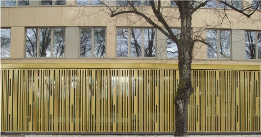 Vorne die Sichtschutzfassade aus Metall, dahinter die Holzfassade