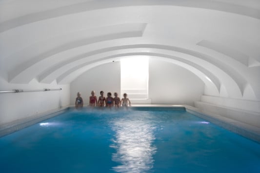Das Schwimmbad befindet sich im Souterrain, wo das alte Kellergewölbe freigelegt und weiß verputzt wurde