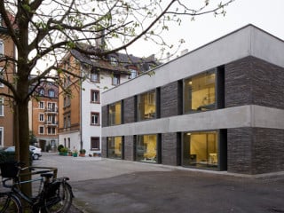 Großzügige Fensterflächen, Betonbänder und Ziegel prägen die Fassade