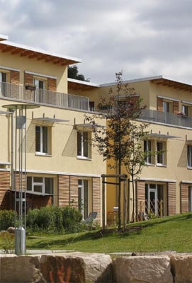 Hofseite: Als Schutz vor solaren Wärmeintrag im Sommer wurden Schiebeläden und kleine Vordächer montiert