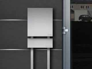 Standbriefkasten mit Zeitungsrolle an einem Einfamilienhaus 