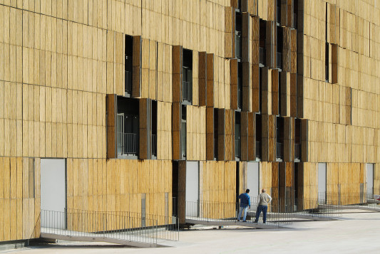 Die Bambusmatten der Fassade sind auf Metallrahmen aufgebördelt