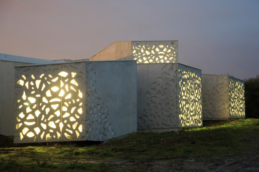 Lichtdurchlässige Betonfassade am Abend