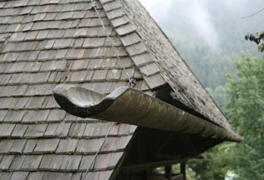 Dach eines Schwarzwaldhauses mit Holzschindeln und hölzerner Regenrinne