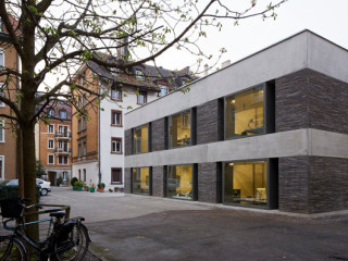 Großzügige Fensterflächen, Betonbänder und Ziegel prägen die Fassade